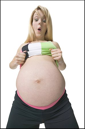 pregnant surprise - Low angle view of a pregnant woman looking at her stomach Stock Photo - Premium Royalty-Free, Code: 640-01349347