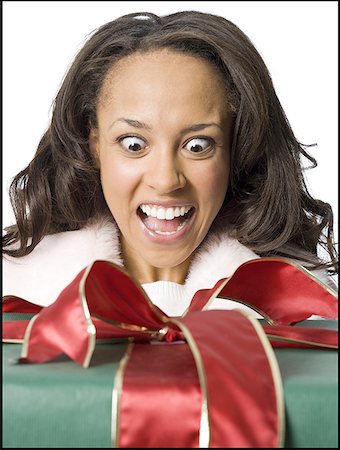 simsearch:640-01358649,k - Close-up of a young woman looking at a wrapped gift Fotografie stock - Premium Royalty-Free, Codice: 640-01349355