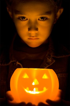 Portrait d'un garçon tenant une lanterne de Jack o ' rougeoyante Photographie de stock - Premium Libres de Droits, Code: 640-01349357