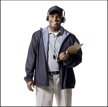 person on phone with clipboard - Coach with clipboard and headset smiling Stock Photo - Premium Royalty-Free, Code: 640-01349434