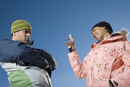 simsearch:640-01354485,k - Low angle view of a young woman taking a photograph of an adult man Stock Photo - Premium Royalty-Free, Code: 640-01349475