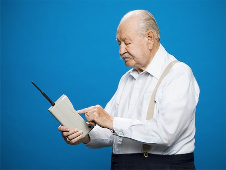 simsearch:400-04596625,k - Older man making call on retro wireless phone Stock Photo - Premium Royalty-Free, Code: 640-01349498