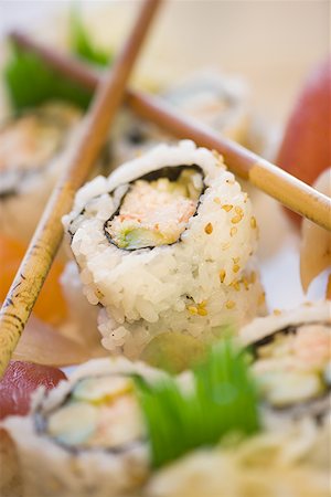 Close-up of sushi rolls with chopsticks Stock Photo - Premium Royalty-Free, Code: 640-01349515