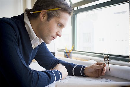 exam success - Profile of an architect looking over a blueprint Stock Photo - Premium Royalty-Free, Code: 640-01349553