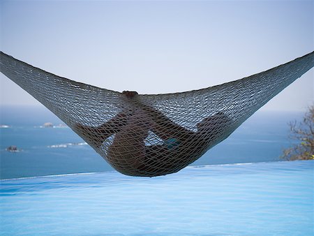 Profile of a young woman relaxing in a hammock Stock Photo - Premium Royalty-Free, Code: 640-01349624