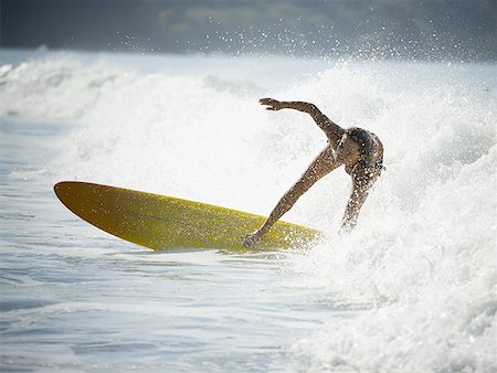parco manuel antonio - Young woman surfing on a surfboard Fotografie stock - Premium Royalty-Free, Codice: 640-01349627