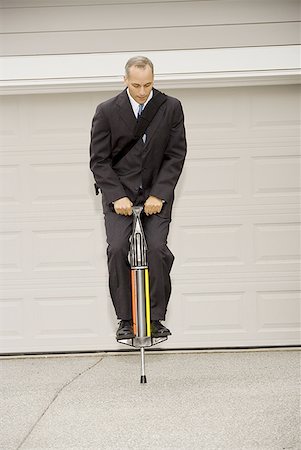 Businessman on a pogo stick Stock Photo - Premium Royalty-Free, Code: 640-01349706