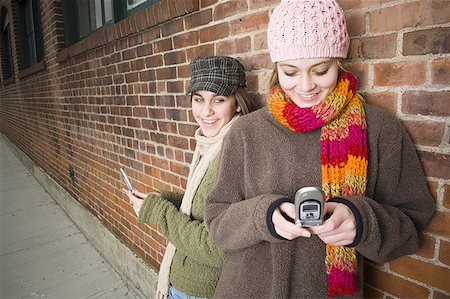Two girls using mobile phones Stock Photo - Premium Royalty-Free, Code: 640-01349829