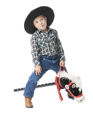 pictures blue jeans cowboy boots - Boy riding a hobby horse Stock Photo - Premium Royalty-Free, Code: 640-01349849