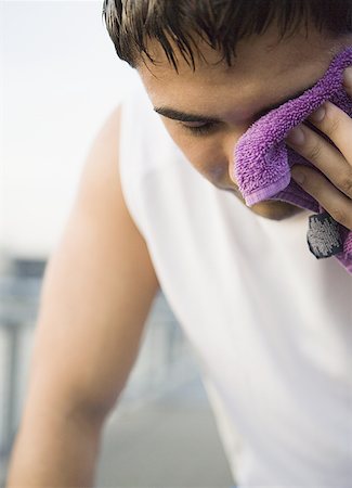 Close-up of a mid adult man wiping his face with a towel Stock Photo - Premium Royalty-Free, Code: 640-01349887
