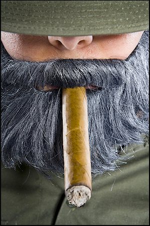Close-up of a mid adult man smoking a cigar Fotografie stock - Premium Royalty-Free, Codice: 640-01349937