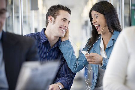 Woman sharing her MP3 player with a young man on a commuter train Stock Photo - Premium Royalty-Free, Code: 640-01349969