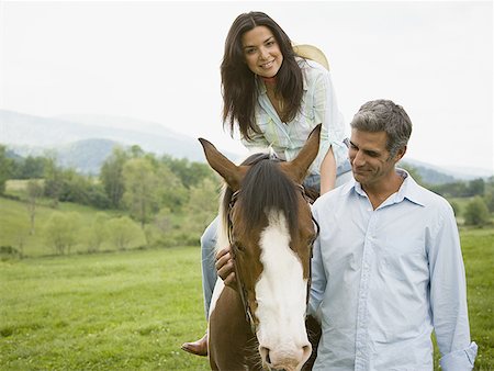 woman sitting on a horse with a man beside her Stock Photo - Premium Royalty-Free, Code: 640-01349997