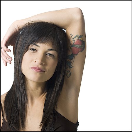 portrait and woman and closeup and arms - Woman with arm resting on head and heart tattoo Stock Photo - Premium Royalty-Free, Code: 640-01354017