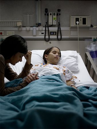 sick girl in bed - High angle view of a mother holding her daughter's hand Stock Photo - Premium Royalty-Free, Code: 640-01354184