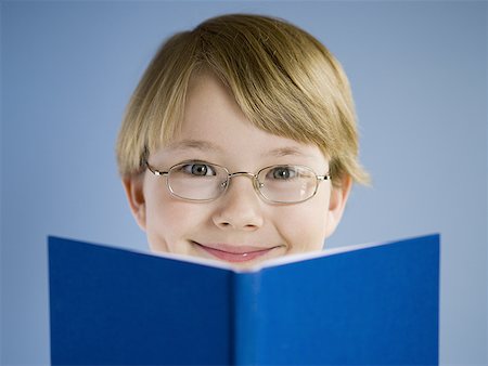 Boy reading book and smiling Stock Photo - Premium Royalty-Free, Code: 640-01354292
