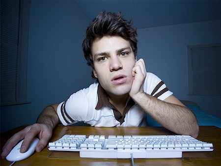 Man with hand on mouse and keyboard watching Stock Photo - Premium Royalty-Free, Code: 640-01354307
