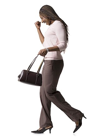 simsearch:640-01353774,k - Profile of a young woman walking with a hand bag Stock Photo - Premium Royalty-Free, Code: 640-01354320