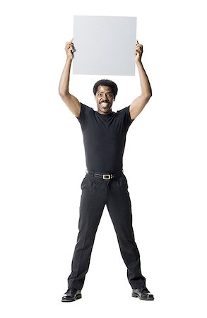 simsearch:640-01350507,k - A man smiling and holding a blank sign Stock Photo - Premium Royalty-Free, Code: 640-01354339