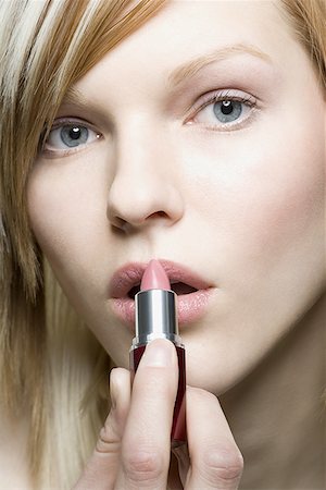 Portrait d'une jeune femme, appliquer le rouge à lèvres Photographie de stock - Premium Libres de Droits, Code: 640-01354415