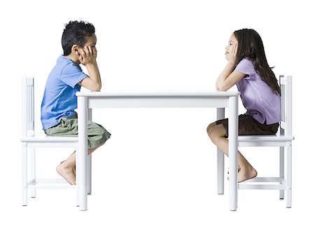 simsearch:640-02772735,k - Boy and girl sitting at table with hands on faces Stock Photo - Premium Royalty-Free, Code: 640-01354458