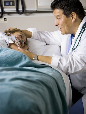 simsearch:640-03261406,k - Male doctor talking to young girl in hospital bed Stock Photo - Premium Royalty-Free, Code: 640-01354511