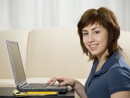 simsearch:640-01360985,k - Portrait of a teenage girl using a laptop and smiling Foto de stock - Royalty Free Premium, Número: 640-01354570
