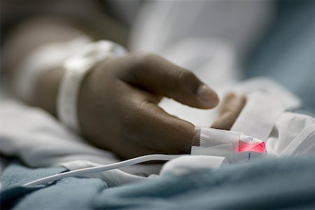 Close-up of a patient's hand in a hospital bed Stock Photo - Premium Royalty-Free, Code: 640-01354606