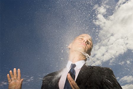 Low angle view of a businessman getting hosed Stock Photo - Premium Royalty-Free, Code: 640-01354770