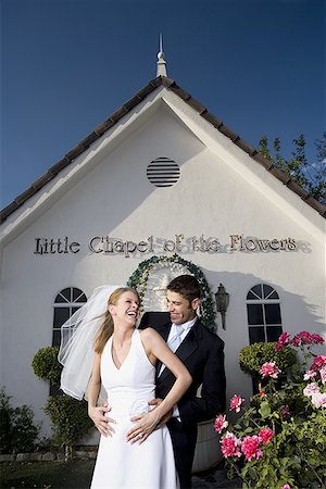 simsearch:640-01351306,k - Debout de couple de jeunes mariés devant une chapelle et souriant Photographie de stock - Premium Libres de Droits, Code: 640-01354796