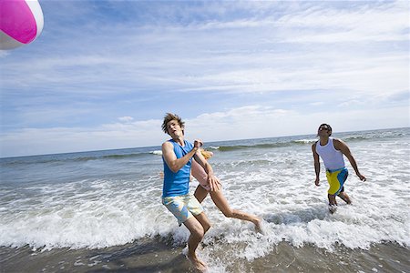 Three young people playing with a beach ball in the sea Stock Photo - Premium Royalty-Free, Code: 640-01354803