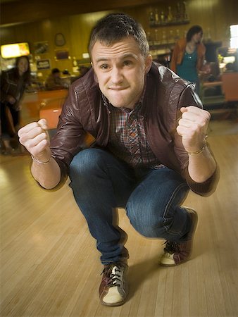 Young man cheering in excitement at a bowling alley Stock Photo - Premium Royalty-Free, Code: 640-01354820
