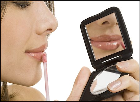 Close-up of a woman applying lip- gloss Stock Photo - Premium Royalty-Free, Code: 640-01354897