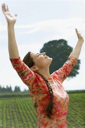 Woman with arms in air basking in sun Stock Photo - Premium Royalty-Free, Code: 640-01354910