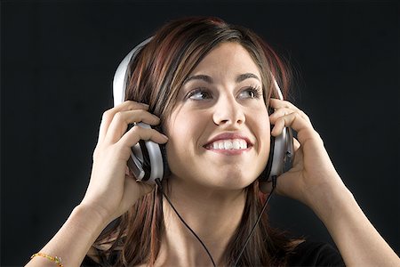 Close-up of a young woman listening to music on headphones Stock Photo - Premium Royalty-Free, Code: 640-01354981