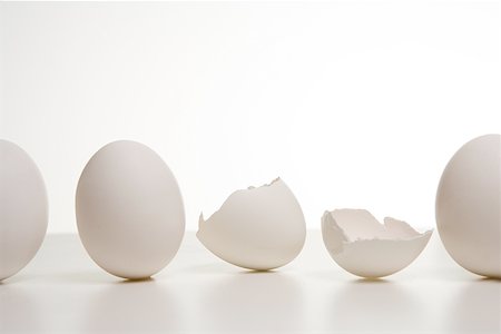 simsearch:640-02657375,k - Une ligne d'oeufs avec un oeuf cassé Photographie de stock - Premium Libres de Droits, Code: 640-01355312