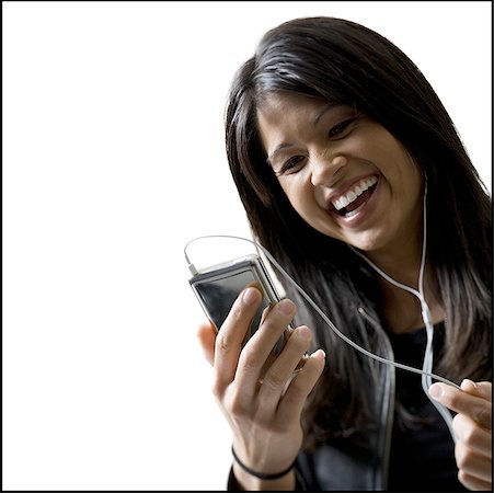 Close-up of a young woman listening to an MP3 player Stock Photo - Premium Royalty-Free, Code: 640-01355346