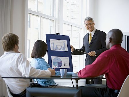 Businessmen and a businesswoman in a meeting Stock Photo - Premium Royalty-Free, Code: 640-01355384