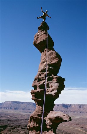 simsearch:640-01349855,k - Low angle view of a person standing on the top of a rock formation Foto de stock - Sin royalties Premium, Código: 640-01355438