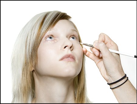 Close-up of a person's hand applying eyeliner on a young woman's eyes Stock Photo - Premium Royalty-Free, Code: 640-01355491