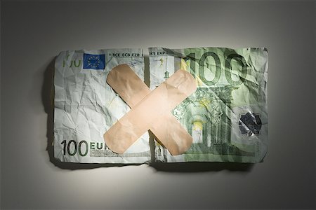 Torn one hundred euro banknote with bandages Stock Photo - Premium Royalty-Free, Code: 640-01355567