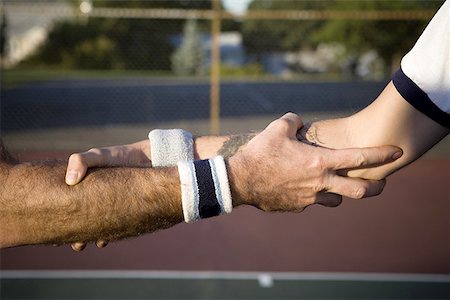 Close-up of two tennis players shaking hands Stock Photo - Premium Royalty-Free, Code: 640-01355594