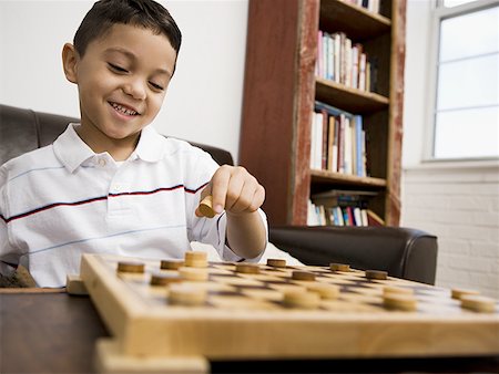 Young boy playing checkers Stock Photo - Premium Royalty-Free, Code: 640-01355666