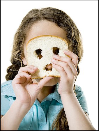sliced brown bread - Portrait of a girl looking through a slice of bread Stock Photo - Premium Royalty-Free, Code: 640-01355717