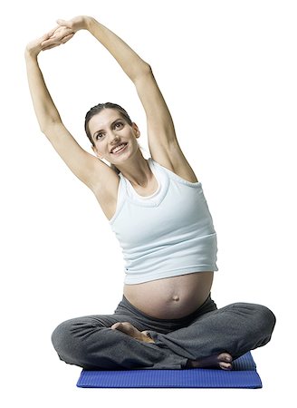 Portrait of a pregnant woman sitting on the floor stretching Stock Photo - Premium Royalty-Free, Code: 640-01355755