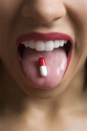 simsearch:649-09207396,k - Close-up of a young woman with a capsule on her tongue Foto de stock - Sin royalties Premium, Código: 640-01355854