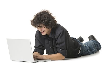 Adolescent à l'aide d'un ordinateur portable et souriant Photographie de stock - Premium Libres de Droits, Code: 640-01355858
