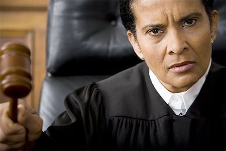 Portrait of a female judge holding a gavel and looking serious Stock Photo - Premium Royalty-Free, Code: 640-01355931