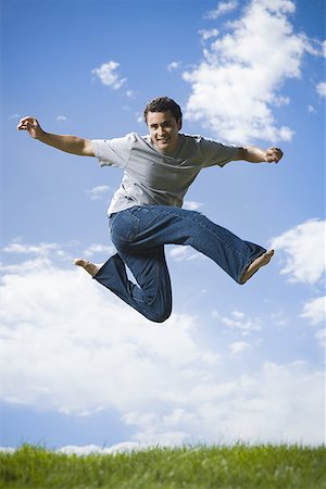 Low angle view of a young man jumping Stock Photo - Premium Royalty-Free, Code: 640-01355981