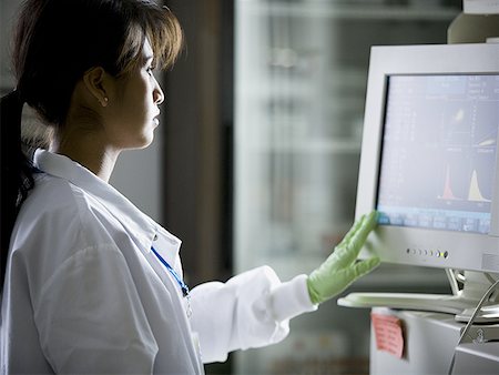 Female lab technician looking at monitors Stock Photo - Premium Royalty-Free, Code: 640-01356027